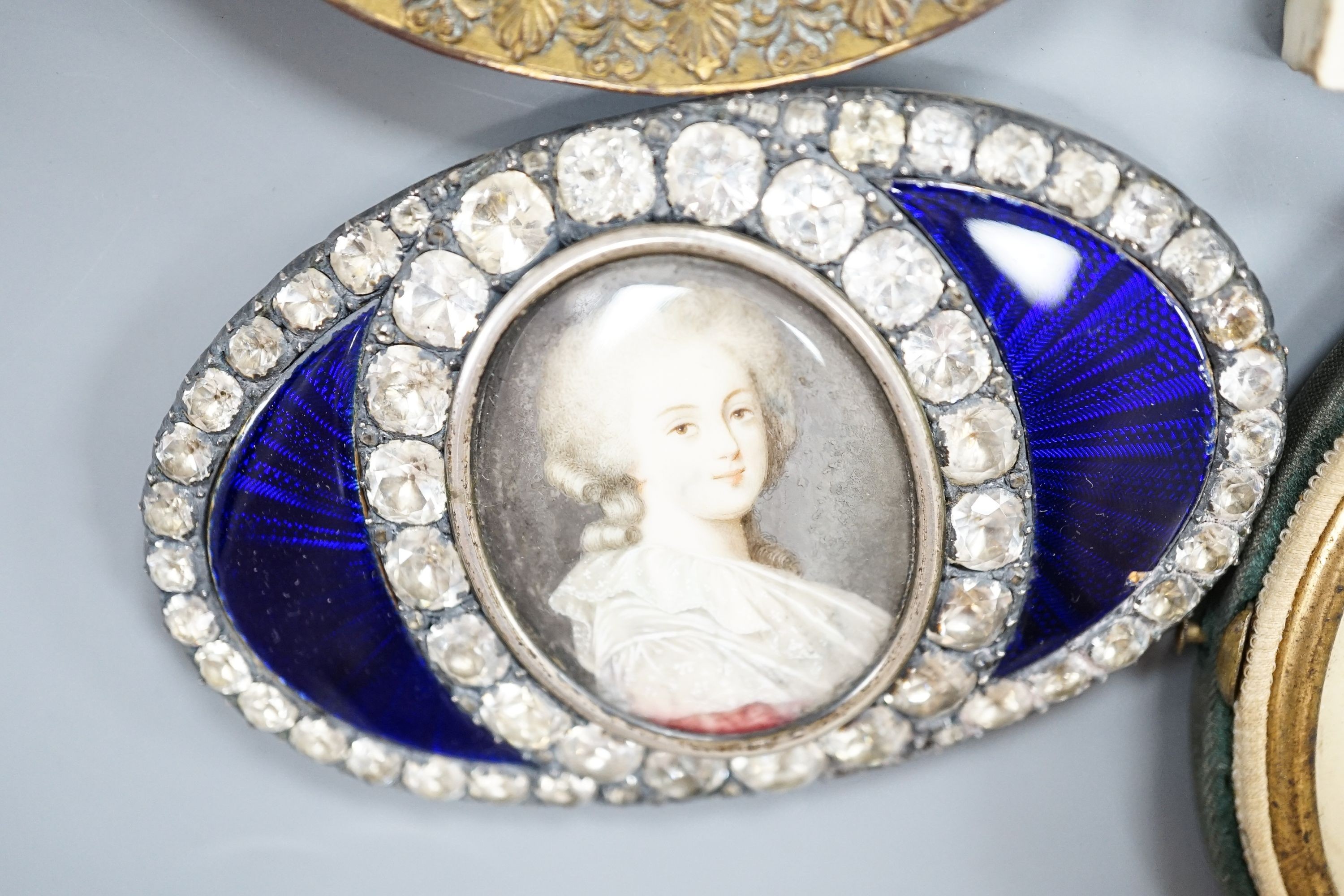 A paste and enamel framed Portrait miniature on ivory, 9.2cm and four other portrait miniatures (three on ivory)